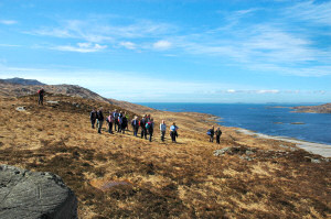 Picture of a group of walkers on a hill above a sea loch in brilliant sunshine