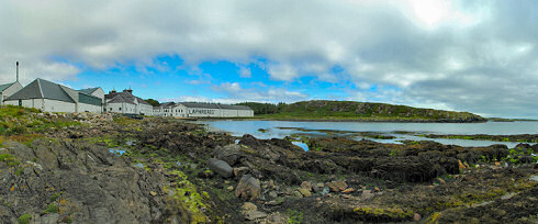 Picture of a panoramic view over a sea loch with a distillery on the shore