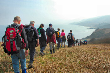 Picture of a group of walkers lining up to walk down to a sound (the Sound of Islay)