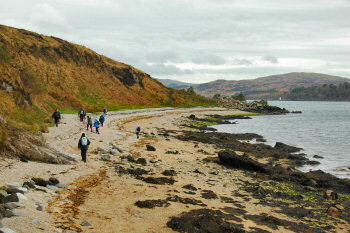 Picture of a group of walkers on a pebble beach