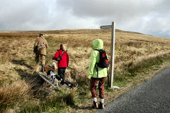 Picture of walkers crossing a small bridge to Evan's Walk