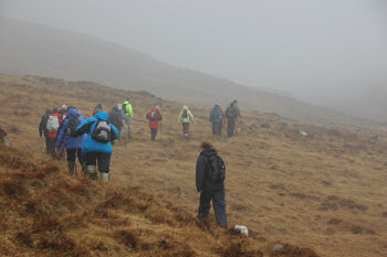 Picture of a group of walkers disappearing into the rain