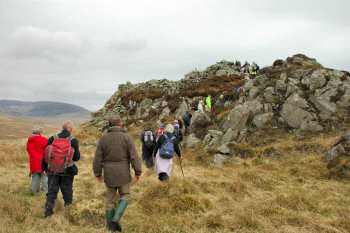 Picture of walkers climbing up to an old hillfort