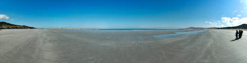 Picture of a beach under a clear blue sky with bright sunshine