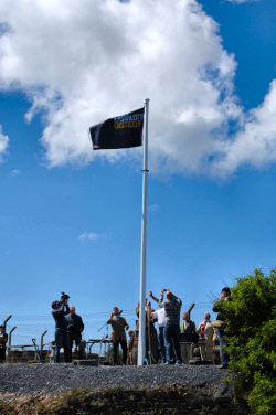 Picture of the Port Charlotte Distillery standard being raised