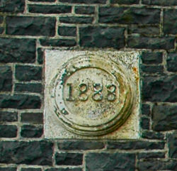 Picture of a plaque with the year 1888 in the wall of a building