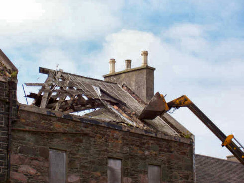 Large parts of the roof are gone, the rest was going to follow soon Picture of a digger taking down an old roof