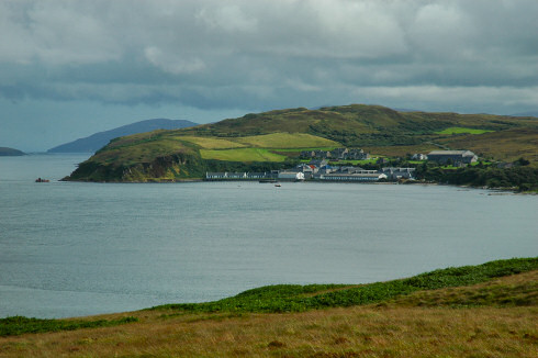 Picture of a wide bay with a distillery on a sound between two islands