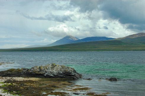 Picture of a view over a sound between two island, a large mountain on the other island