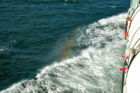 Picture of a small rainbow visible in the spray of the bow wave of a ship