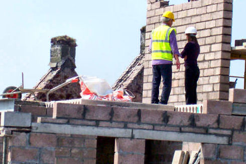Picture of two people on top of a building under construction