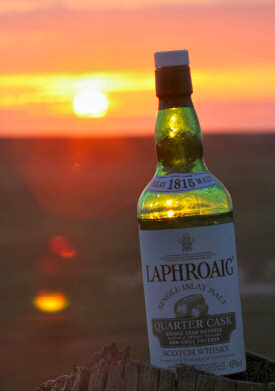 Picture of a bottle of Laphroaig Quarter Cask Islay Single Malt whisky under a beautiful sunset