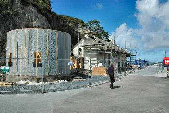 Picture of a construction site with a round building and an old house being refurbished
