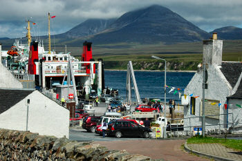 Picture of a small harbour on a sound with cars driving off a large ferry