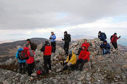 Picture of a group of walkers at the summit cairn and trigpoint of Beinn Bheigier on Islay