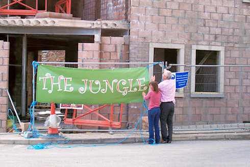 Picture of two people next to a banner reading The Jungle