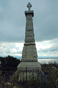 Picture of the war memorial at Port Ban between Port Charlotte and Bruichladdich on Islay. A small cross on top of a plinth.