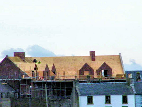 Picture of the back of an under construction hotel with the roof nearing completion