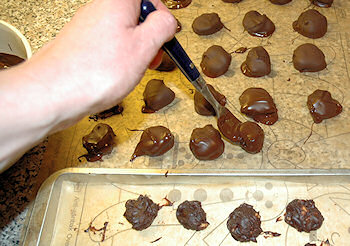 Picture of chocolate truffles being coated in chocolate