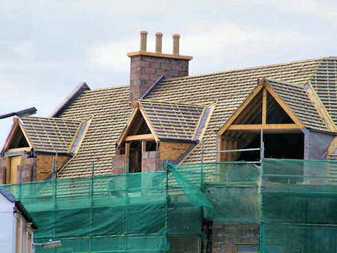 View of the roof with the three chimneys proudly standing at the top of the hotel Picture of the roof of a hotel under construction