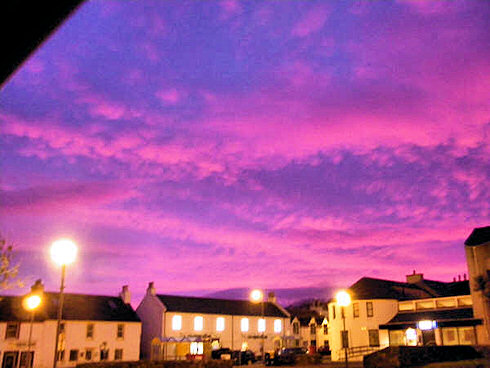 Picture of a colourful morning sky over the main road of a small village
