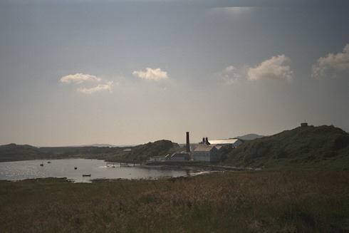 Picture of a whisky distillery (Lagavulin) at a sunny bay on a beautiful sunny day