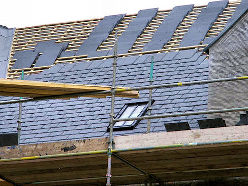 Picture of the under construction roof of a building with the slates going up