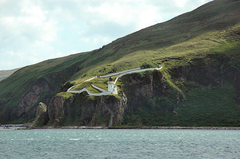 Picture of a lighthouse high on some cliffs, seen from a passing ferry