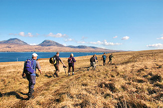 Picture of walkers walking along the Sound of Islay with the Paps of Jura in the background