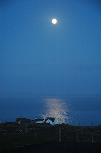 Picture of the moon shining above a small coastal hamlet