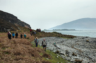 Picture of walkers on the shore of a sound between two islands