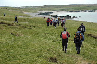 Picture of a group of walkers approaching a bay with a farm