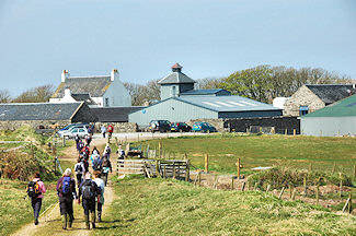 Picture of walkers approaching a farm distillery