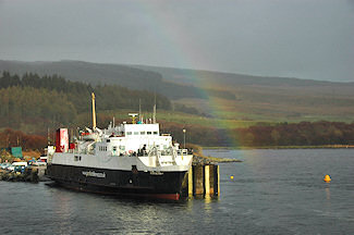 Picture of a old ferry under a partial rainbow