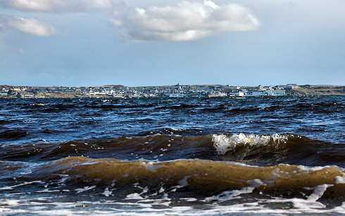 Picture of a village seen across a sea loch from a very low vantage point