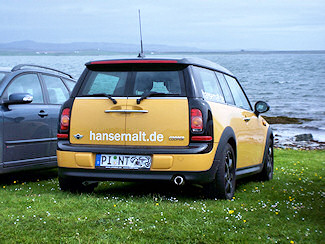 Picture of the back of a yellow Mini Clubman with the lettering hansemalt.de