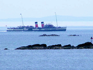 Picture of a paddle steamer cruising along a rocky shore line