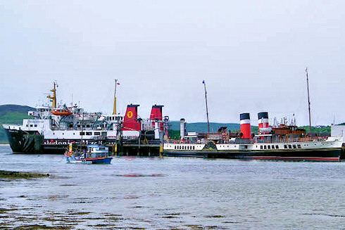 Picture of a paddle steamer at a small pier, a modern car ferry in the background