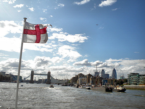 Picture of Tower Bridge in London seen from a river cruise ship, the England flag flying on the bow
