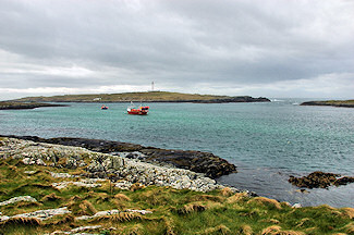 Picture of a small island with a lighthouse seen from a larger island