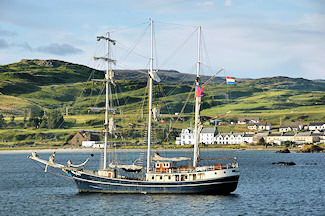 Picture of a tall ship anchored outside a small coastal village