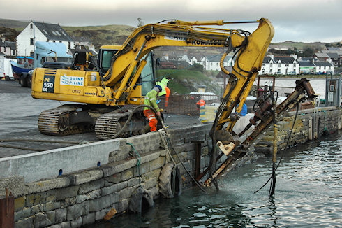 Picture of a digger with a drill attached working on a quay wall