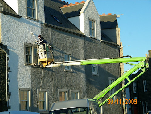 Picture of two painters at work on a cherry picker