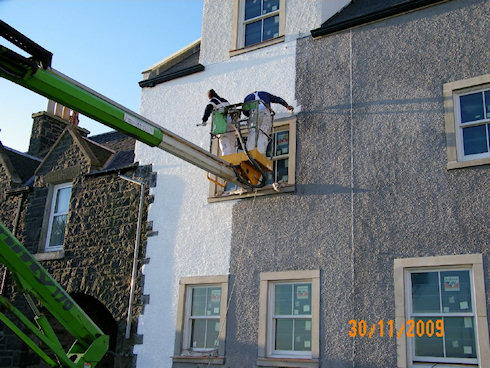Another picture of two painters at work on a cherry picker