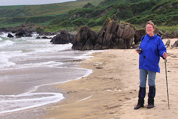 Picture of a woman in a blue jacket on a sandy beach