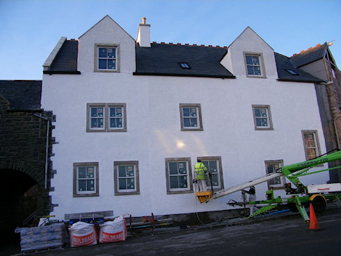 Picture of a hotel being painted white, this side of the building almost finished