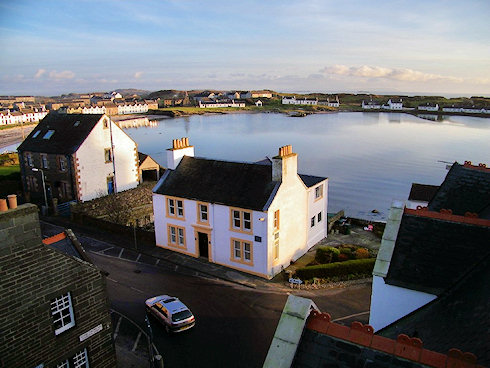 Picture of a white painted building with yellow window and door frames, seen from above