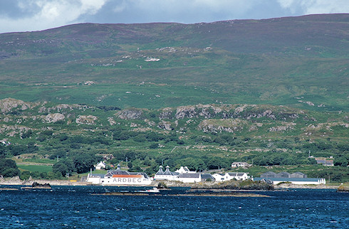 Picture of a distillery seen from a passing ferry, a boat passing the distillery