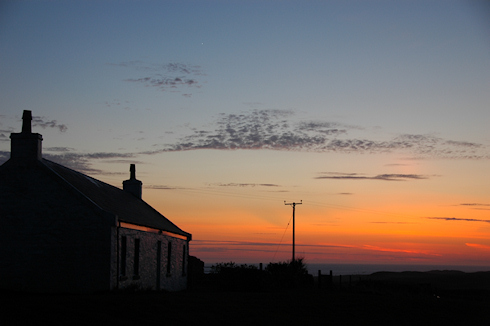 Picture of a colourful evening sky after sunset over a cottage