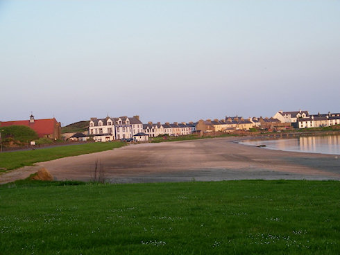 Picture of a wide beach with some houses behind